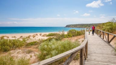 woman and girl walking on footbridge on beach in Cadiz