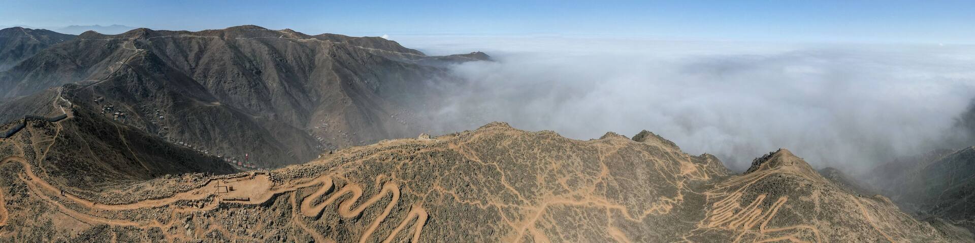 A mountain range with a cloudy sky in the background