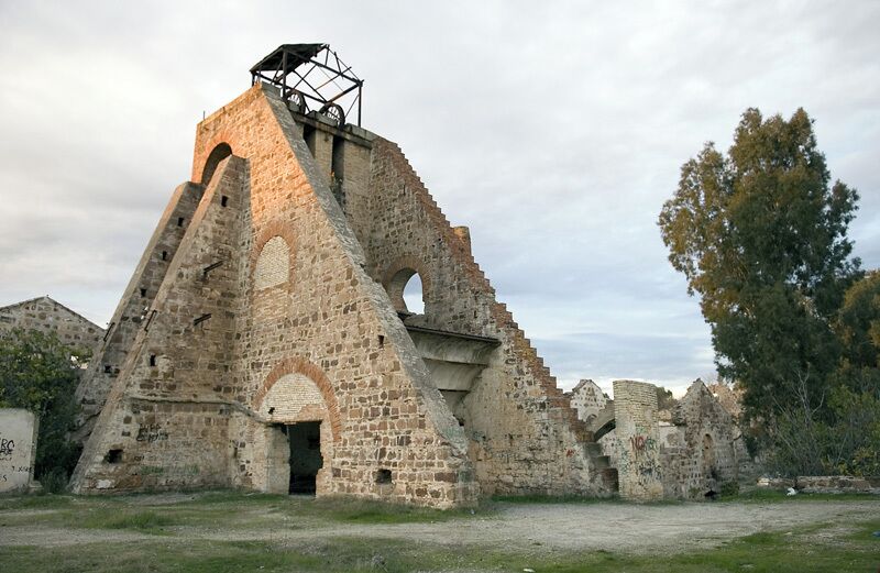 An ancient stone structure with a central tower and arched openings.