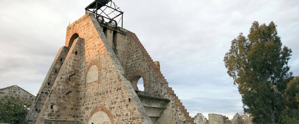 An ancient stone structure with a central tower and arched openings.