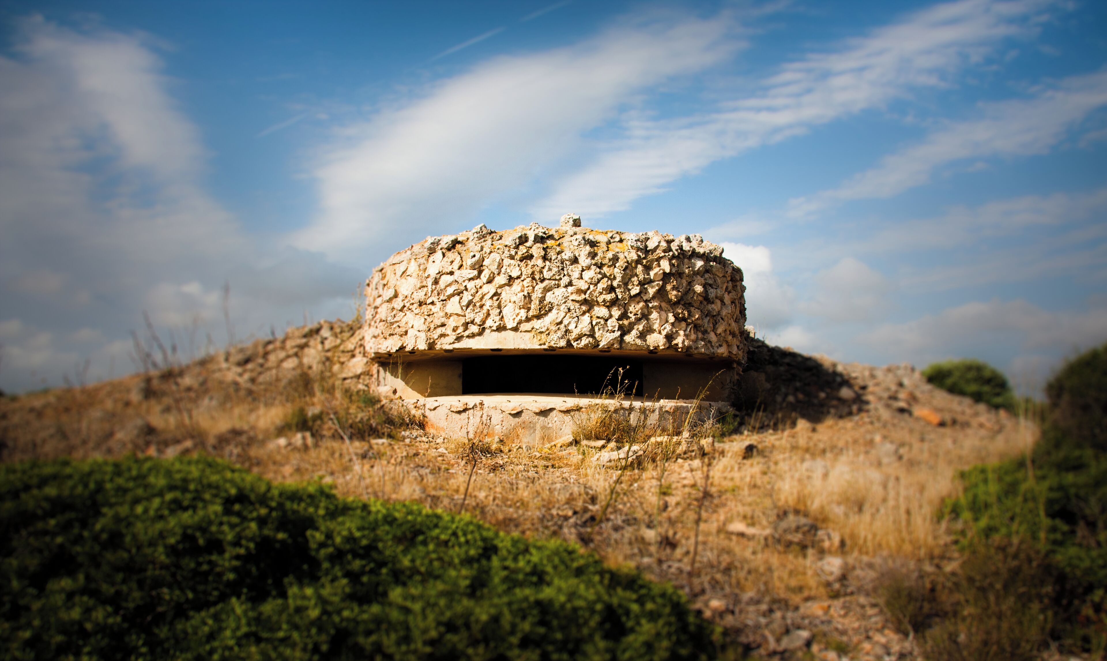 A stone structure on a hill with a clear sky.