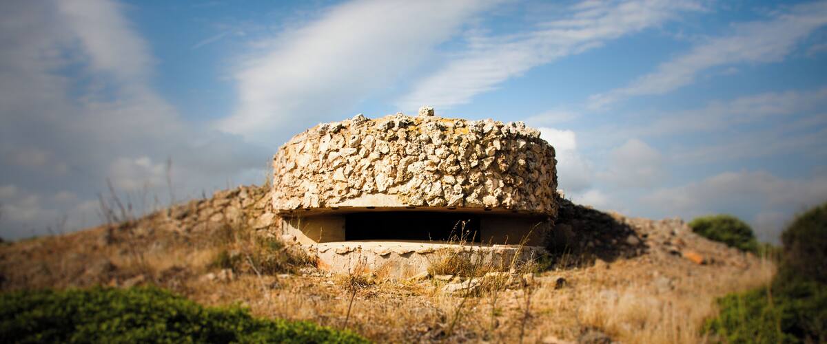 A stone structure on a hill with a clear sky.