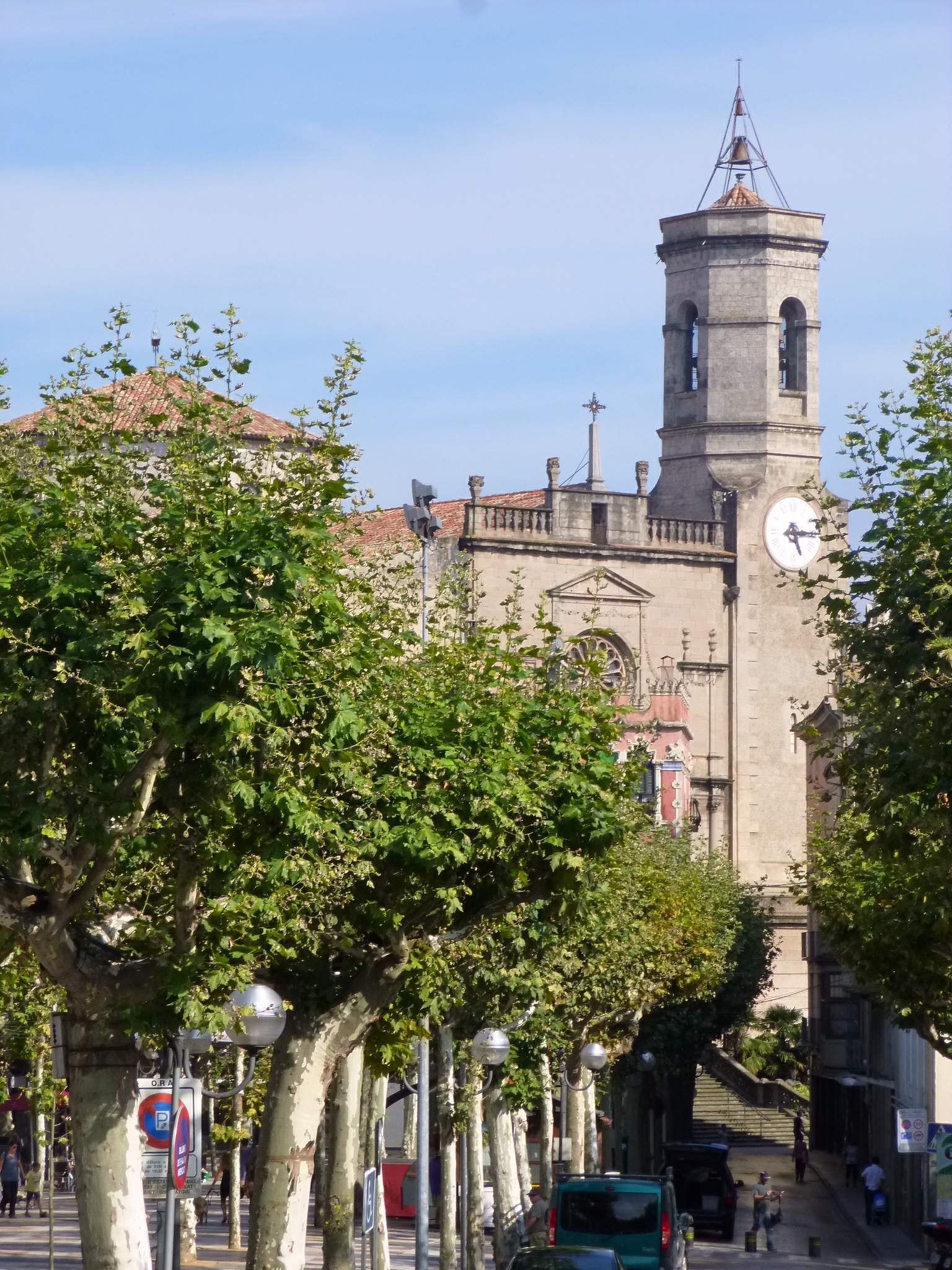 A historic building with a clock tower, surrounded by trees and street lamps.