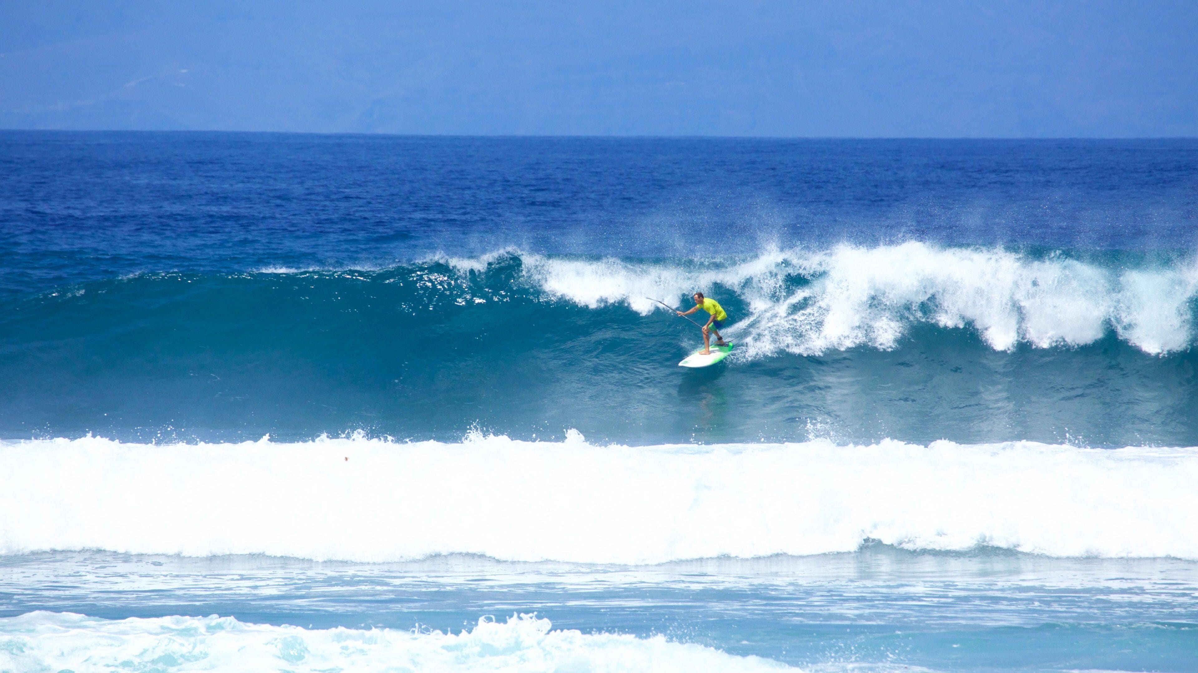 Un surfista montando una ola grande en el océano.
