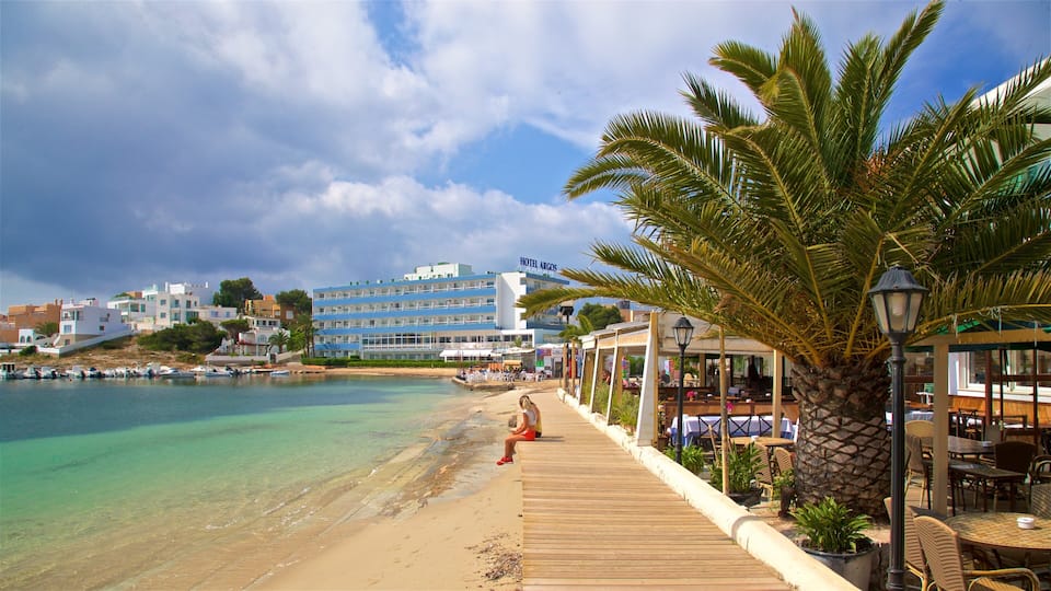 A beach with a wooden walkway, palm trees, and a hotel named 'Hotel Argos' in the background.
