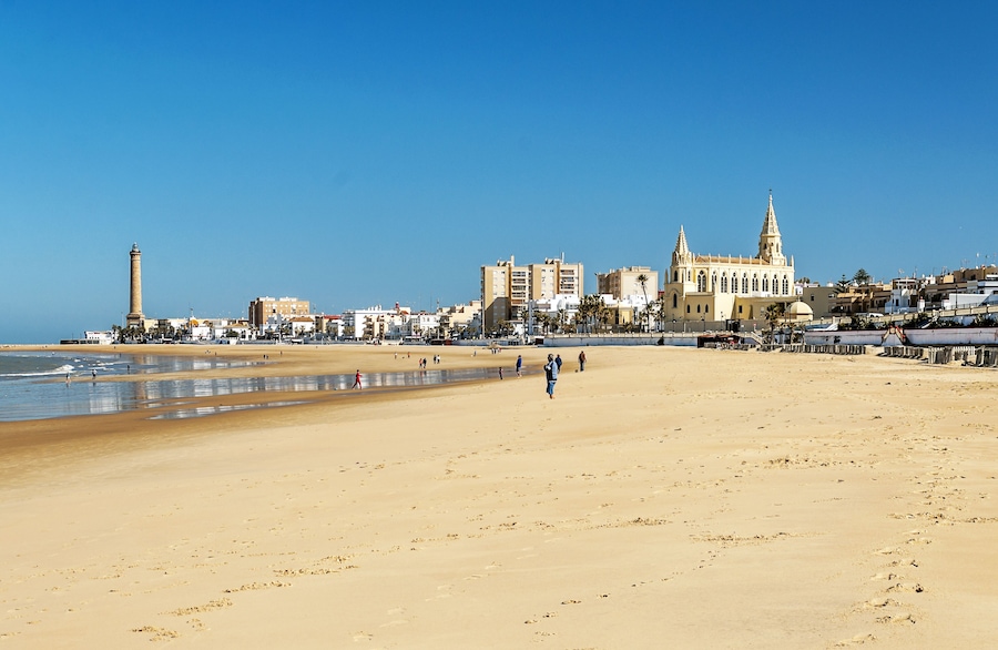 Chipiona, Cadiz, Spain-June 2016. Tourists walking along the beach of the turistic municipality of the coast of light in Cadiz on a sunny day.