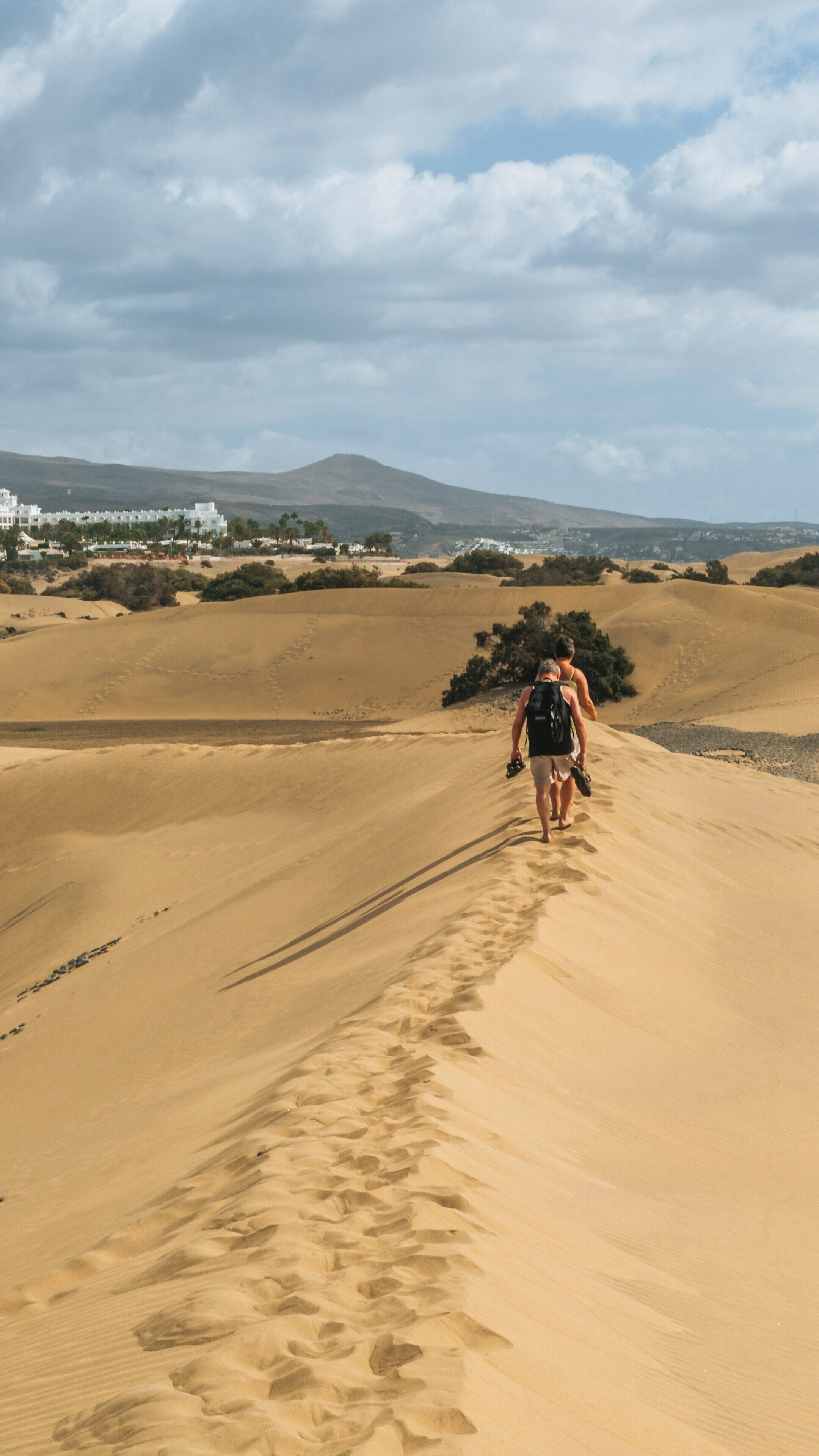 Strolling through the Maspalomas Dunes during a sunny day in San Bartolome de Tirajana, Canary Islands, Spain