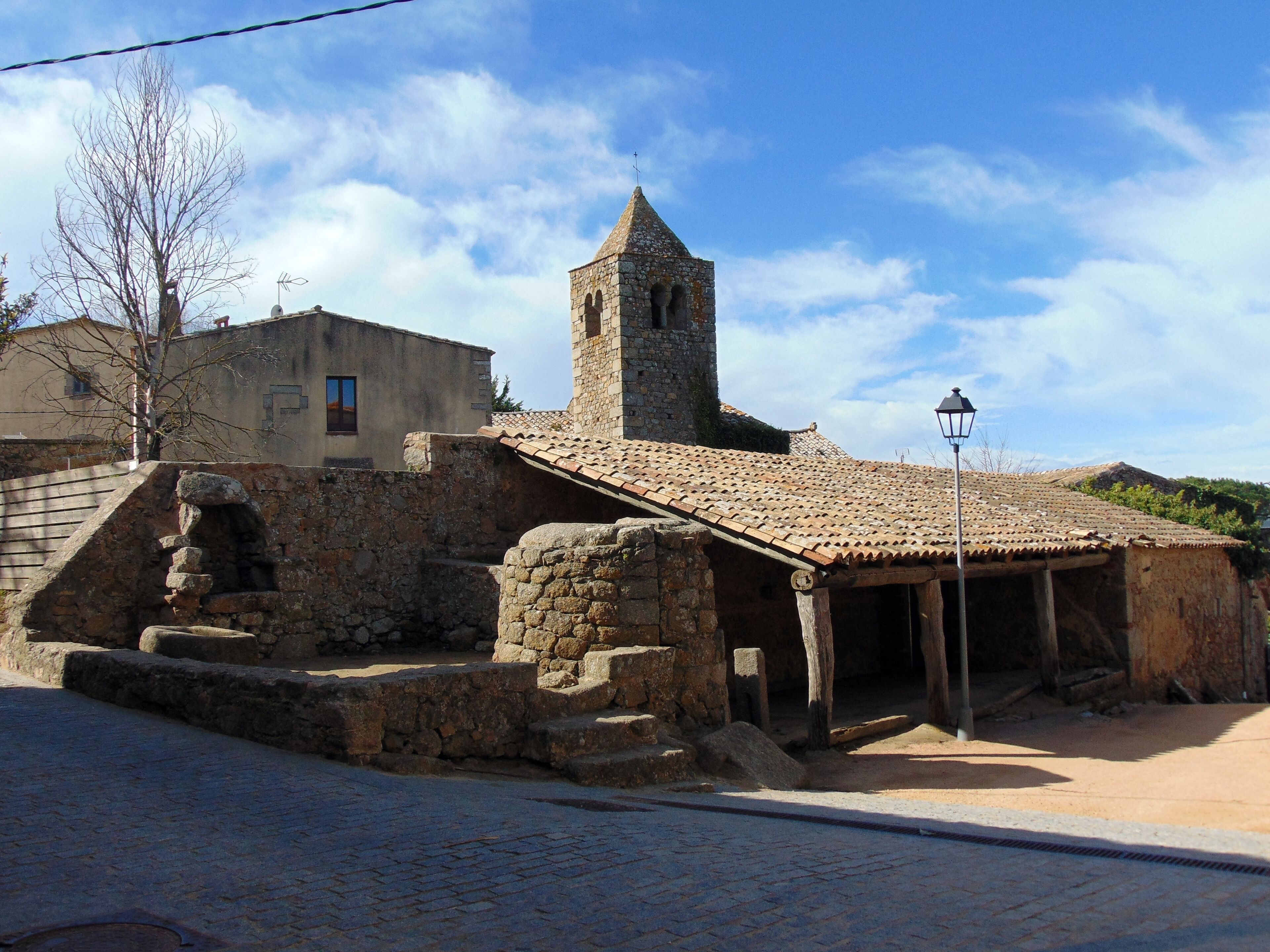 A stone building with a tiled roof and a tower.