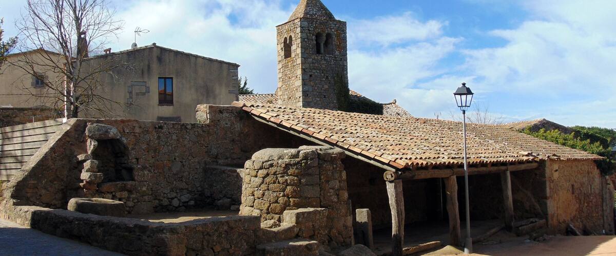 A stone building with a tiled roof and a tower.