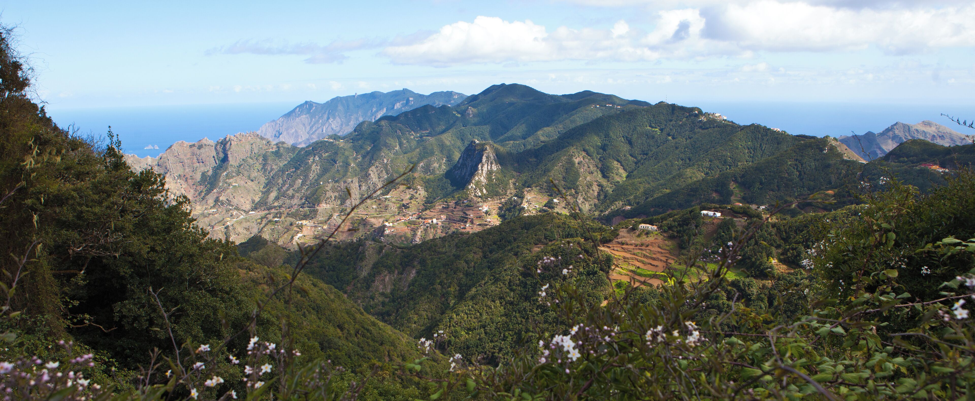 A mountainous landscape with terraced fields and scattered buildings.