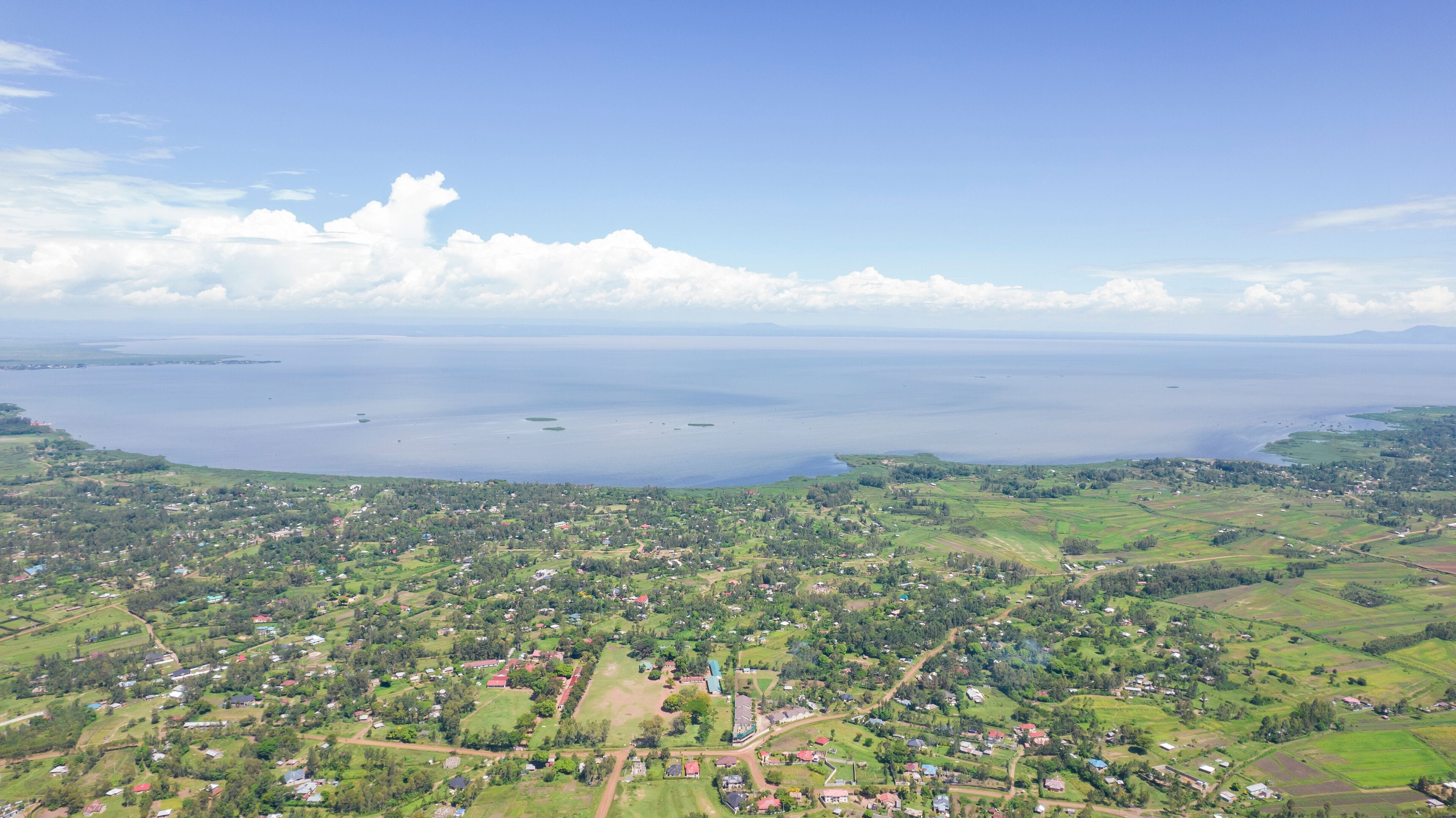 Aerial view of serene Lake Victoria with lush greenery and tranquil countryside, Kisian, Kenya.