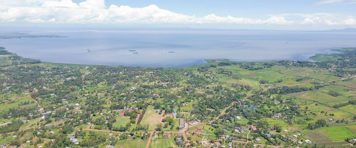 Aerial view of serene Lake Victoria with lush greenery and tranquil countryside, Kisian, Kenya.