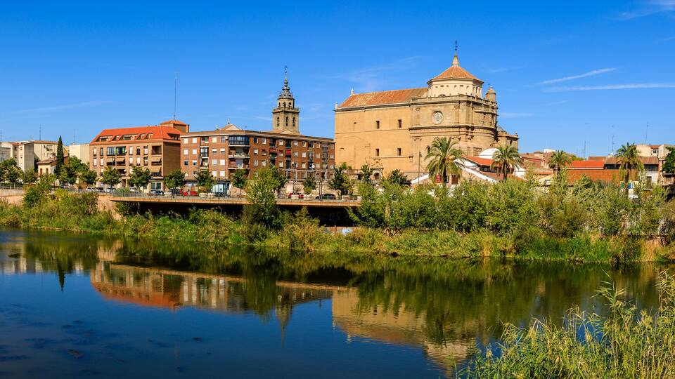 A river with a bridge, buildings, and a prominent historical building with a dome.