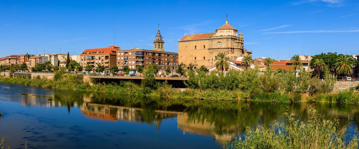 A river with a bridge, buildings, and a prominent historical building with a dome.