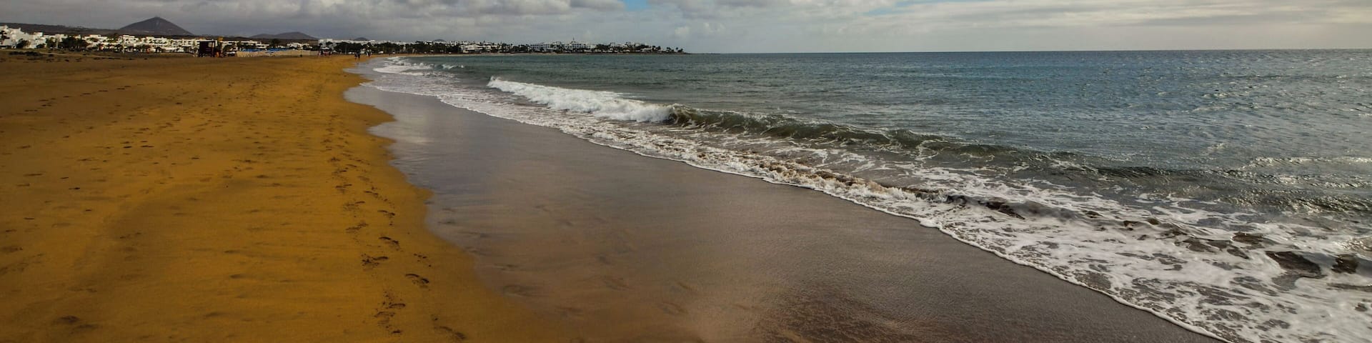 Looking towards Matagorda and Arricife on Los Pocillos beach. You can spot many low flying aircraft on their final approach to Lanzarote Arricife airport.