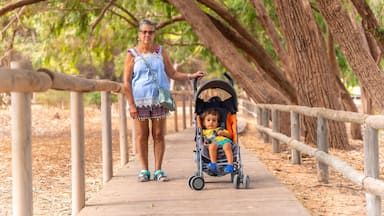 An elderly lady with her grandson walking on the path of the Lagunas de la Mata Natural Park in Torrevieja, Alicante