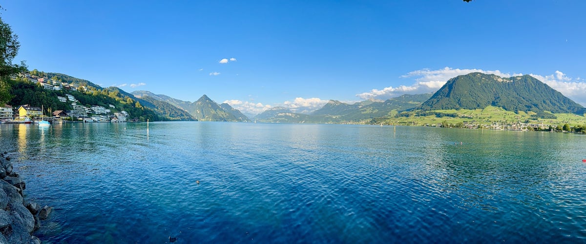 A calm lake surrounded by mountains and houses.