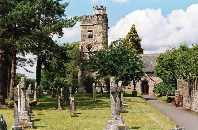 A historic church with a tower, surrounded by a cemetery with gravestones.