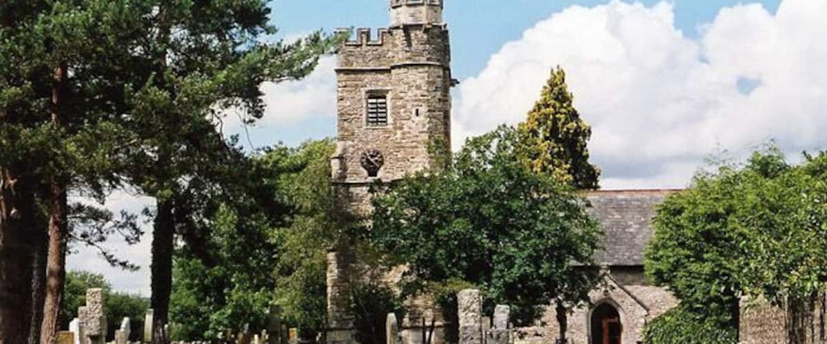 A historic church with a tower, surrounded by a cemetery with gravestones.
