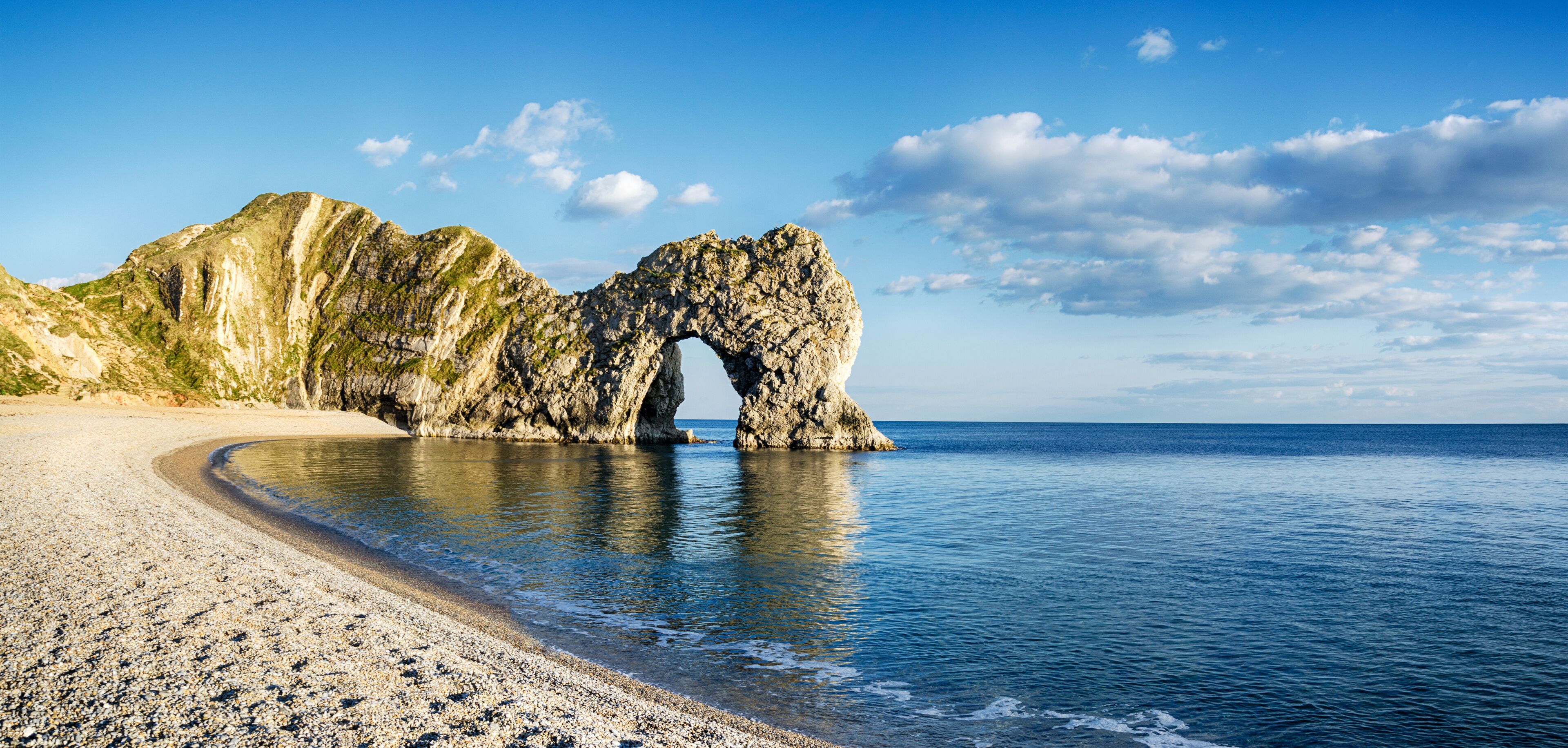 A coastal landscape with a prominent rock arch formation.