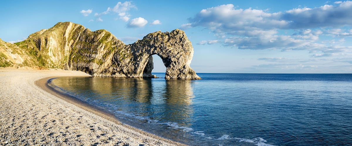 A coastal landscape with a prominent rock arch formation.