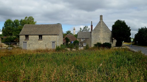 Hawkesbury Upton pond (in the foreground) with farm buildings behind. The Somerset Monument can be seen in the distance.