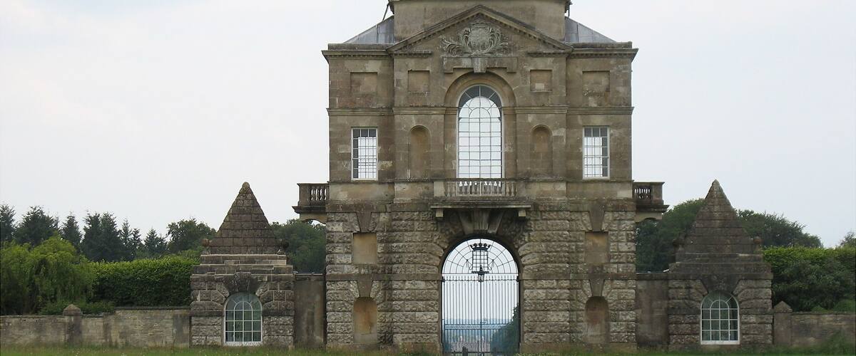 Un edificio histórico de piedra con una gran entrada en arco y una cúpula.