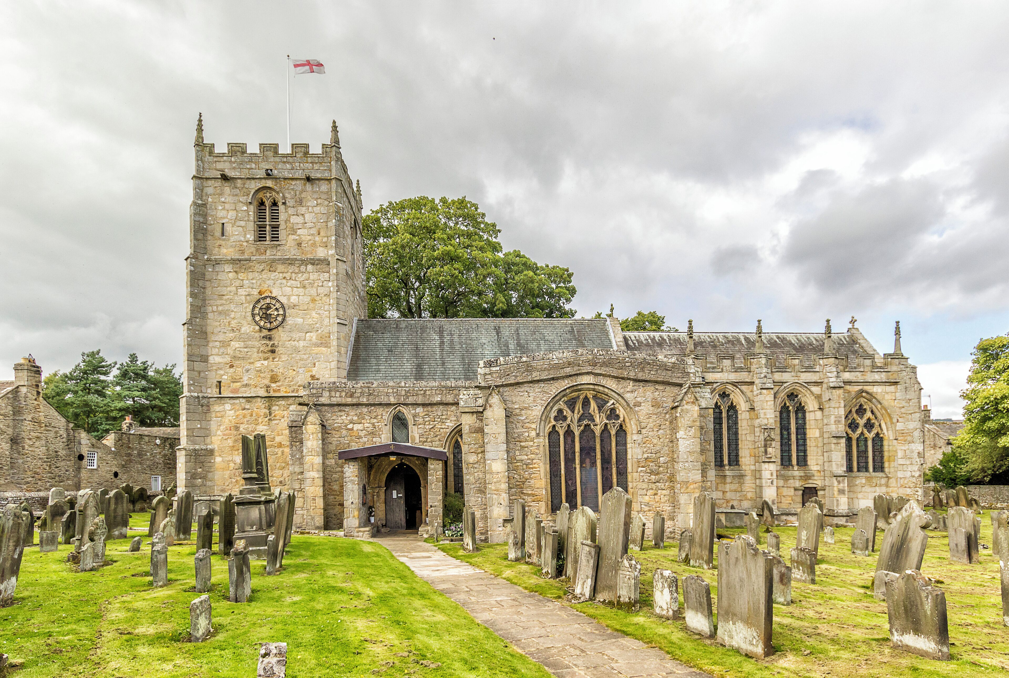 A historic church with a tall tower and a graveyard.