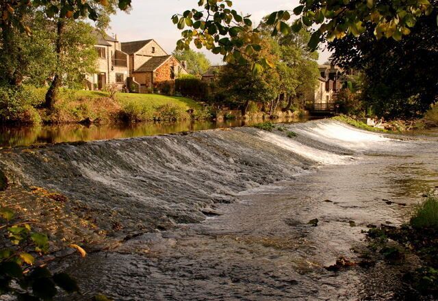Un río serpentea por una zona residencial con casas a sus orillas.