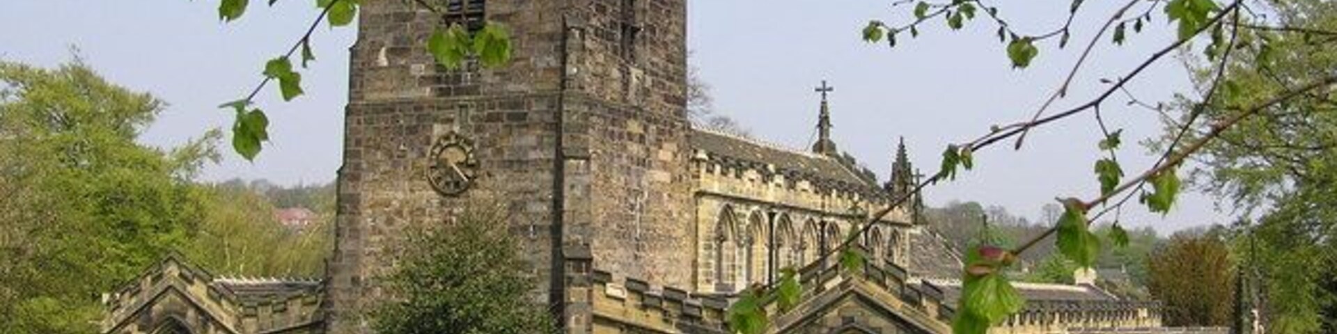 Una iglesia histórica con una torre alta y ventanas de arco.