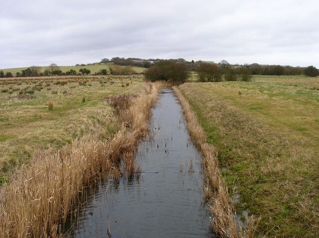 Drainage Ditch, Hooe Level View from the footbridge as the drain travels straight ahead then turns 90 degrees to the right to lin up with Stream Ditch a larger drain. Old Road Farm can be seen on the higher ground in the distance.