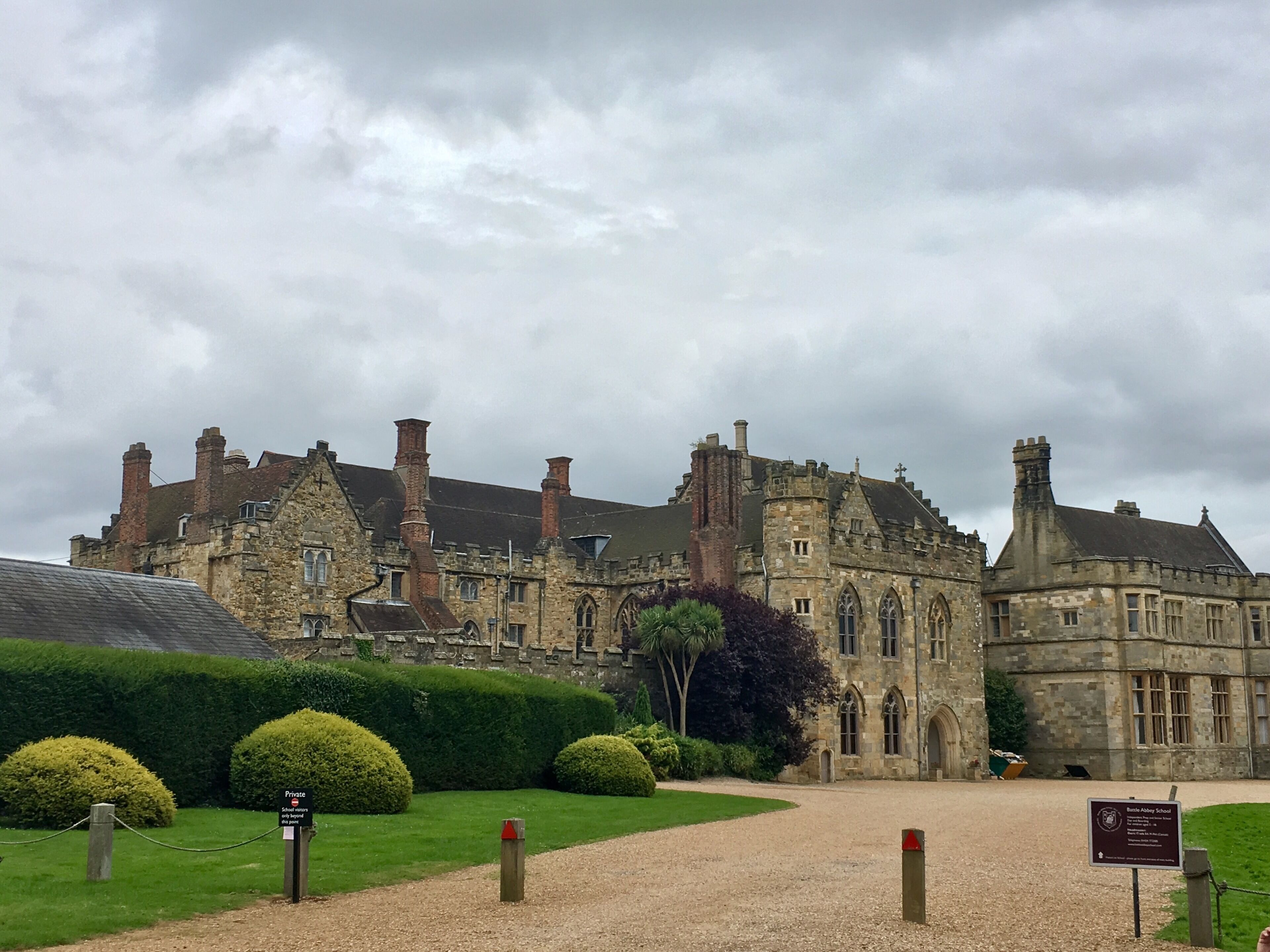 A historic stone building with multiple chimneys and arched windows.