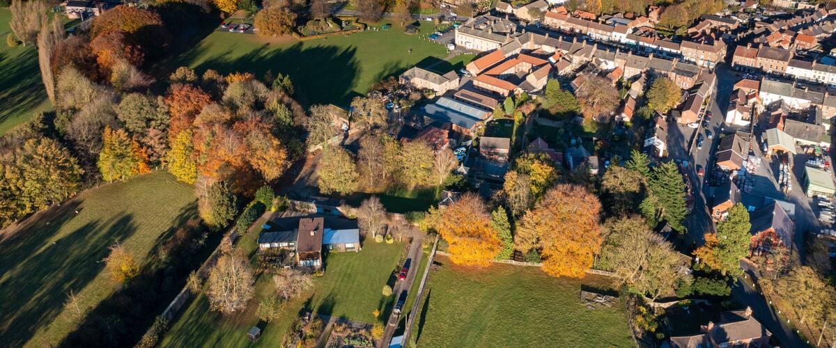 Aerial photo of the beautiful town of Bedale which is a market town in the Hambleton former district of North Yorkshire showing the beautiful town, church and motorway in the autumn time