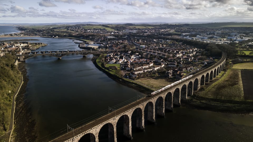 A river with a bridge and a town in the background.