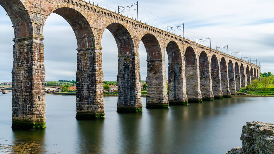 A stone bridge with multiple arches over a river.