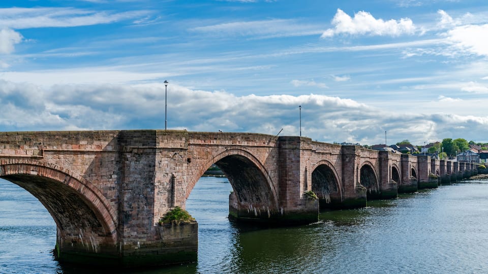 A stone bridge with multiple arches over a river.