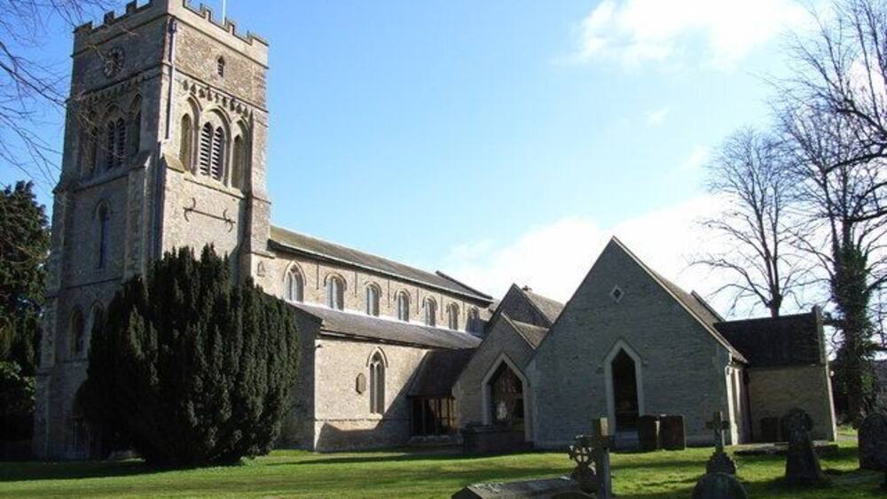 A church with a tall tower and a smaller building with a pointed roof.