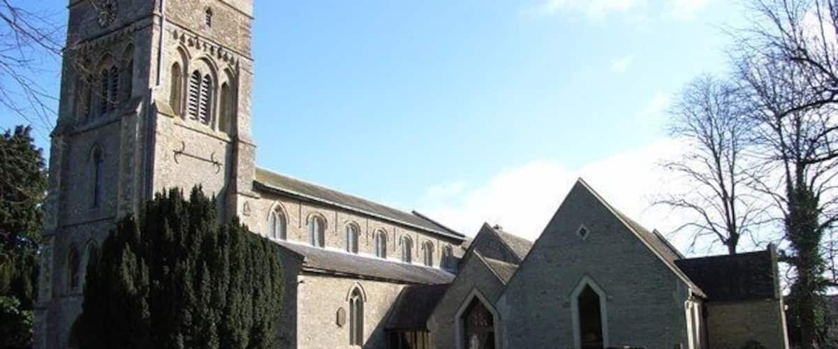 A church with a tall tower and a smaller building with a pointed roof.