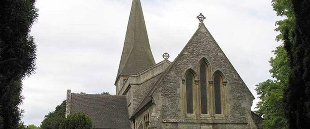 A stone church with a tall spire and arched windows.
