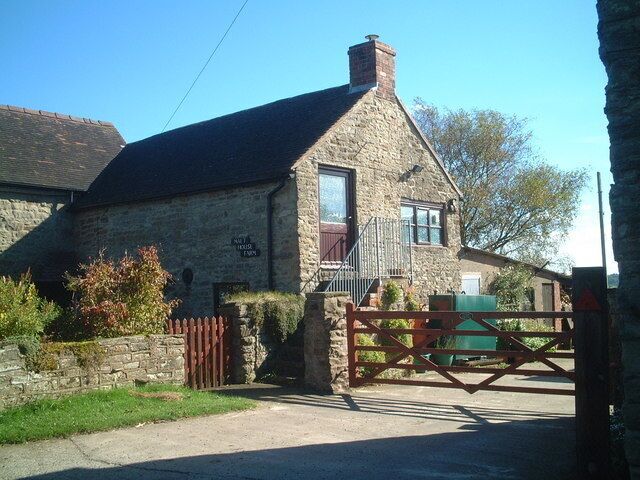 A stone house with a wooden gate and a stone wall.