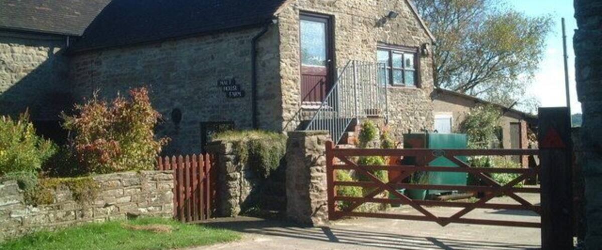 A stone house with a wooden gate and a stone wall.