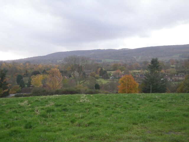 Grassy field in front of Neenton Brown Clee looms behind the village.