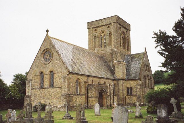 A historic church with a prominent tower and multiple tombs in the foreground.