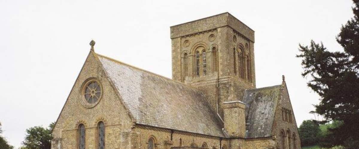 A historic church with a prominent tower and multiple tombs in the foreground.