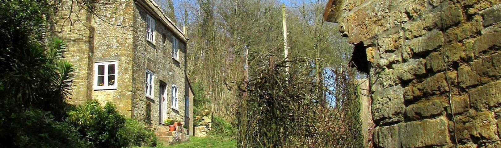 A stone building with a garden path leading to a house.