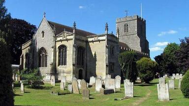 A church with a tall tower and a graveyard.