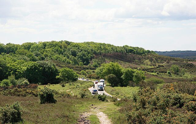 Approaching Burley Street from Picket Post, New Forest. The Picket Post to Burley road descends from Picket Plain and turns ninety degrees left into Burley Street. The hill in background just to right of the road is the fortified Castle Hill.