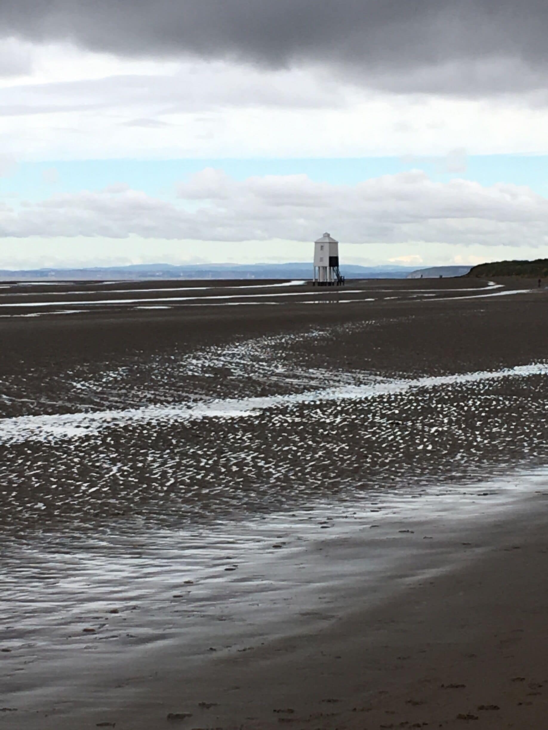 The low lighthouse on the beech at Burnham looking like a de Chirico painting just after high tide and under a heavy sky . 
Park by the pier for a gentle walk to appreciate its setting