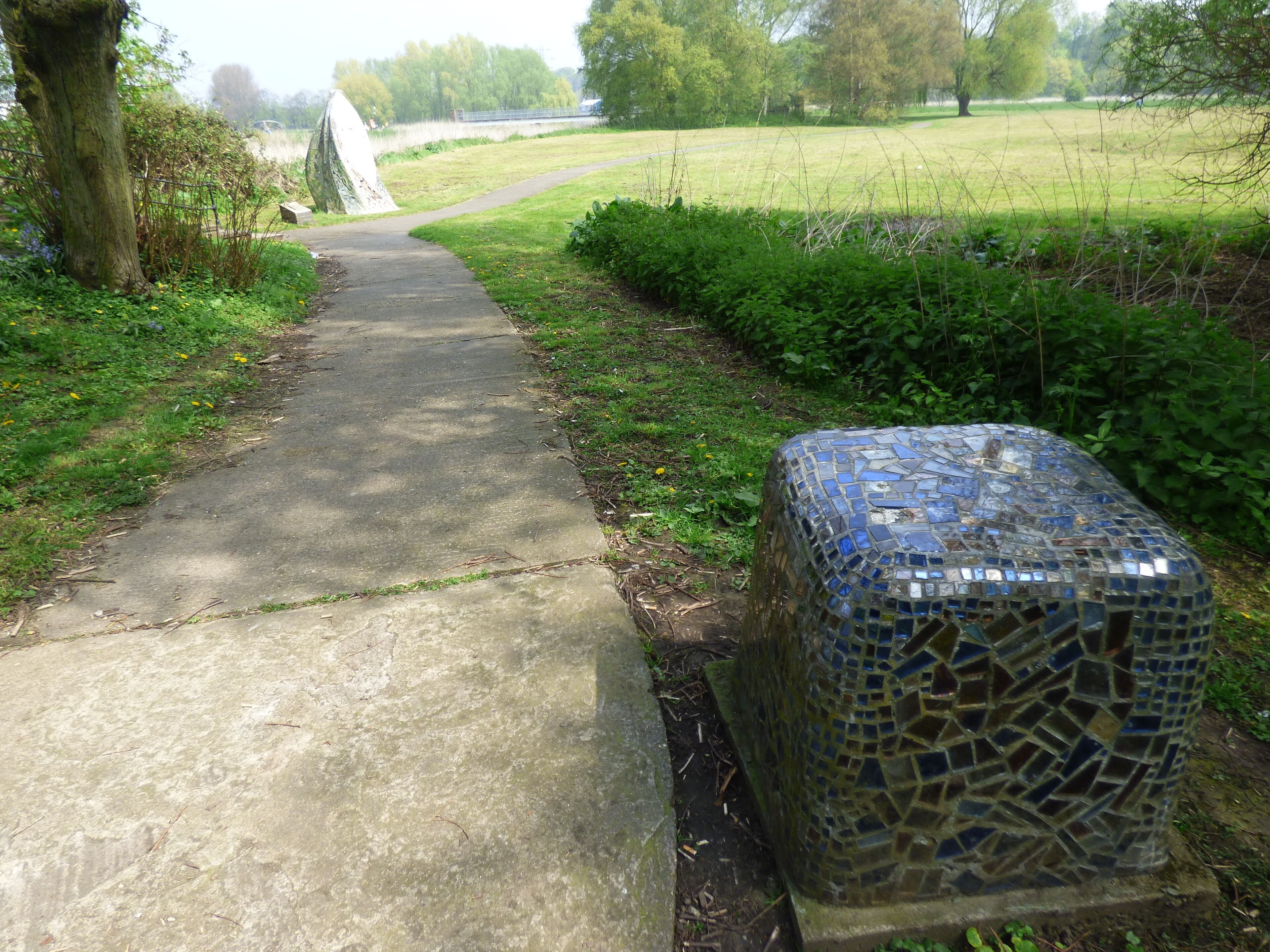 A walk around The Washlands in Burton upon Trent. Around Andressey Island. The River Trent flows past here. Watching the Washlands sculpture, 1993 by Hattie Coppard. Made from Steel, concrete, ceramic tiles, mirror mosaic. The sculptures resemble Indian wayside icons which guard the boundaries of villages from evil. Watching the Washlands It is near the Andressey Bridge.