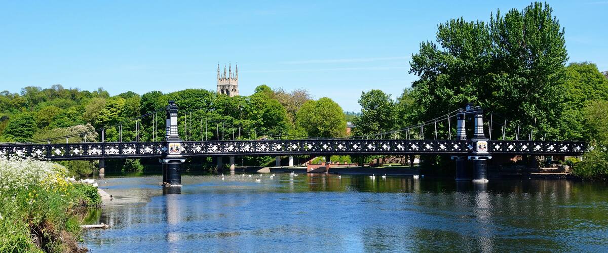 A bridge over a river with a tower in the background.